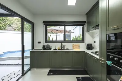 a kitchen with green cabinets and a large window at V215 ChaoFah Oasis Private Pool & Garden Retreat in Phuket Town