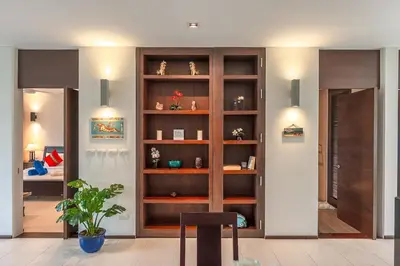 a living room with a wooden book shelf at C215 Pool View 2BR and 200m to Beach Prime Location in Surin Beach
