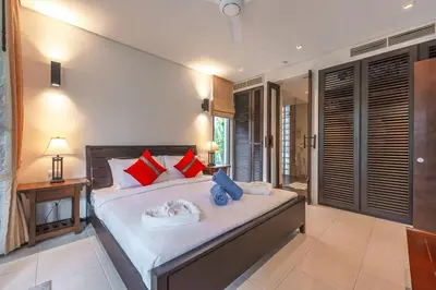 a bedroom with a large bed with red and blue pillows at C215 Pool View 2BR and 200m to Beach Prime Location in Surin Beach