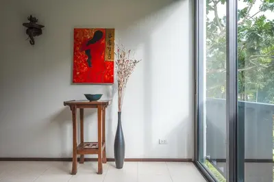 a vase sitting next to a table in a room at C215 Pool View 2BR and 200m to Beach Prime Location in Surin Beach