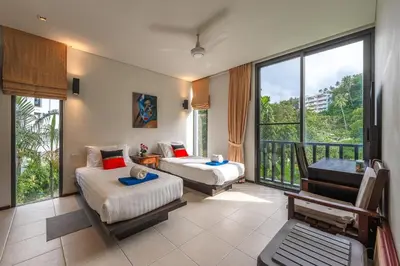 a hotel room with two beds and a balcony at C215 Pool View 2BR and 200m to Beach Prime Location in Surin Beach