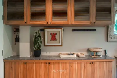 a kitchen counter with wooden cabinets and a plant at Cozy Apartment with Pools Near the Beach in Kamala Beach