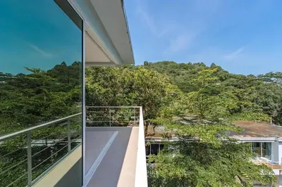 a balcony of a house with a view of trees at Cozy Apartment with Pools Near the Beach in Kamala Beach