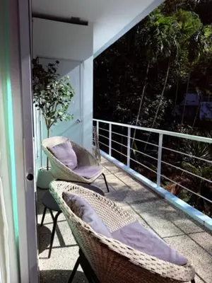 a porch with two chairs and a balcony with a view at Cozy Retreat Near Beach and Pools in Kamala Beach