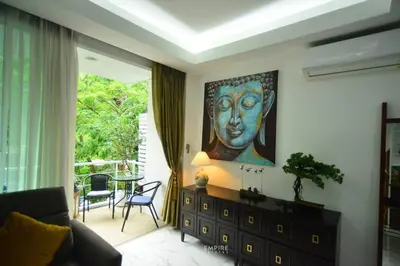 a living room with a painting of a face on the wall at Cozy Retreat Near Beach and Pools in Kamala Beach