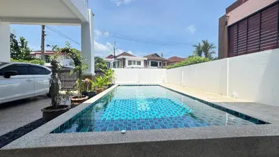 a swimming pool with blue tiles in a backyard at Ban Khuendee Pool Villa in Kathu
