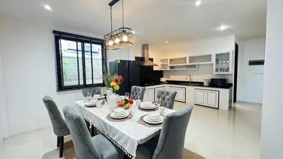 a kitchen and dining room with a table and chairs at Ban Khuendee Pool Villa in Kathu