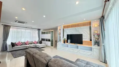 a living room with a couch and a flat screen tv at Ban Khuendee Pool Villa in Kathu