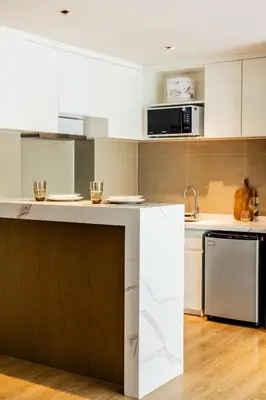 a kitchen with white cabinets and a counter at Suite Elio 1BR PoolsGym Shuttle to Nai Harn in Rawai Beach