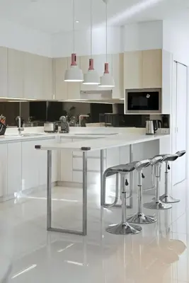 a kitchen with a large white table and stools at Suite Velora 3BR Pool GymCassia Laguna Phuket in Laguna Phuket