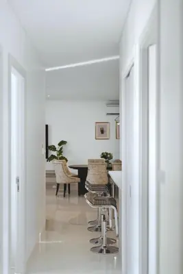 a white hallway with a table and chairs at Suite Velora 3BR Pool GymCassia Laguna Phuket in Laguna Phuket