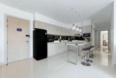 a kitchen with a black refrigerator and a counter at Suite Velora 3BR Pool GymCassia Laguna Phuket in Laguna Phuket