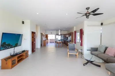 a living room with a couch and a flat screen tv at Karon Bliss Sea View Villa with Private Pool in Karon Beach