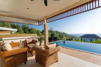 an outdoor patio with wicker chairs and a swimming pool at Karon Bliss Sea View Villa with Private Pool in Karon Beach