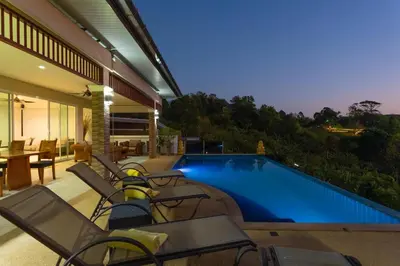 a house with a swimming pool with chairs and a table at Karon Bliss Sea View Villa with Private Pool in Karon Beach