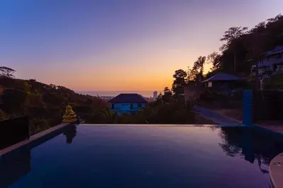 a swimming pool with a sunset in the background at Karon Bliss Sea View Villa with Private Pool in Karon Beach