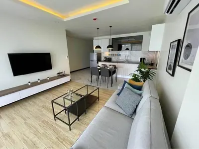 a living room with a couch and a dining room at Sea Breeze 2 Bedrooms Rawai Naiharn Beach in Rawai Beach