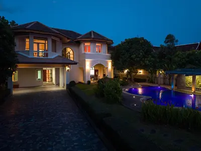 a house with a swimming pool at night at Sundrenched Oasis 7bed pool villa heart of Phuket in Kathu