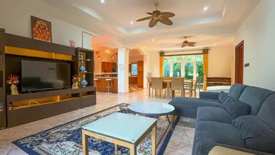 a living room with a blue couch and a tv at Sundrenched Oasis 7bed pool villa heart of Phuket in Kathu