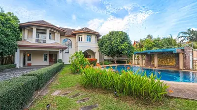 a large house with a swimming pool in front of it at Sundrenched Oasis 7bed pool villa heart of Phuket in Kathu