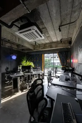 a conference room with tables and chairs and a window at Boss Level Gaming Hotel in Rawai Beach