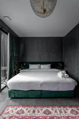 a bedroom with a large bed and a chandelier at Boss Level Gaming Hotel in Rawai Beach