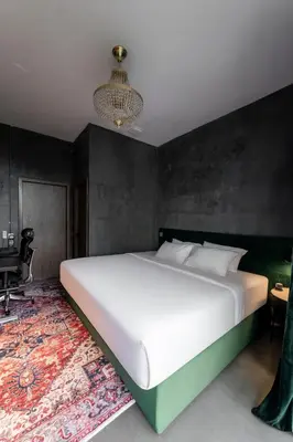 a bedroom with a large white bed and a chandelier at Boss Level Gaming Hotel in Rawai Beach