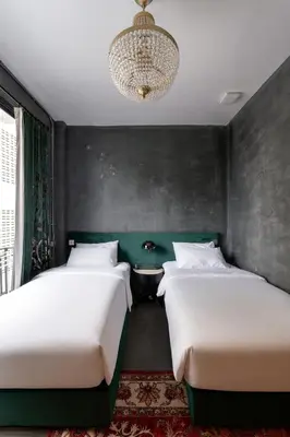 two beds in a bedroom with a chandelier at Boss Level Gaming Hotel in Rawai Beach