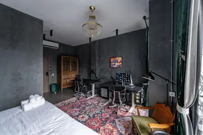 a bedroom with a bed and a desk in a room at Boss Level Gaming Hotel in Rawai Beach