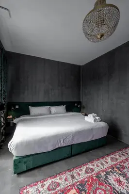 a bedroom with a large white bed with a wall at Boss Level Gaming Hotel in Rawai Beach