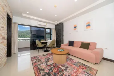 a living room with a pink couch and a table at Apartment with jacuzzi - Patong Tower by lofty in Patong Beach