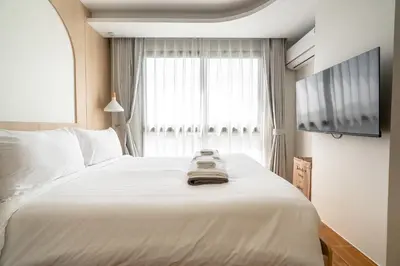 a bedroom with a large white bed and a window at Suite Blue Horizon 2BR Sea View Fantasea Kamala in Kamala Beach