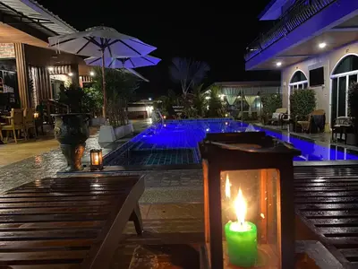 a lit candle next to a swimming pool at night at Kalamung Resort and Pool villas in Ao Nang Beach