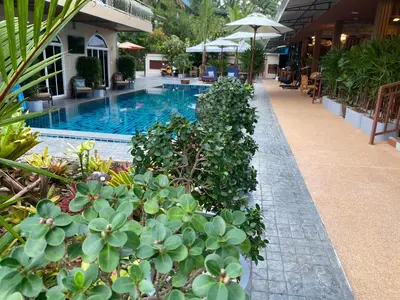 a swimming pool with plants next to a building at Kalamung Resort and Pool villas in Ao Nang Beach