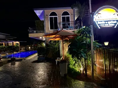 a building with an umbrella next to a pool at night at Kalamung Resort and Pool villas in Ao Nang Beach