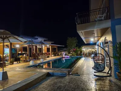 a swimming pool at night with a hotel at Kalamung Resort and Pool villas in Ao Nang Beach