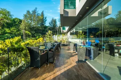 a restaurant with tables and chairs on a balcony at Private apartment at Twin Sands near Merlin beach in Patong Beach