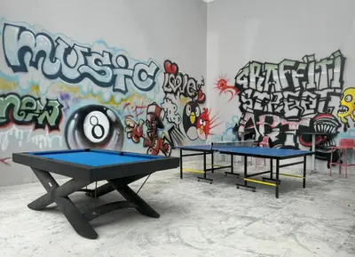 two ping pong tables in front of a wall with graffiti at Private apartment at Twin Sands near Merlin beach in Patong Beach