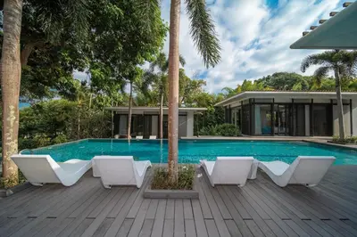 a swimming pool with white chairs and a house at Villa Marina Cape Yamu Luxury 6 Bedroom Seaview Villa, Free Breakfast, Airport Pickup and Drop-off, Servant in Ko Lek