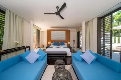 a bedroom with blue couches and a bed and windows at Villa Marina Cape Yamu Luxury 6 Bedroom Seaview Villa, Free Breakfast, Airport Pickup and Drop-off, Servant in Ko Lek