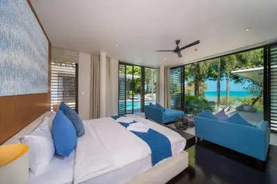 a bedroom with a large bed and blue chairs at Villa Marina Cape Yamu Luxury 6 Bedroom Seaview Villa, Free Breakfast, Airport Pickup and Drop-off, Servant in Ko Lek