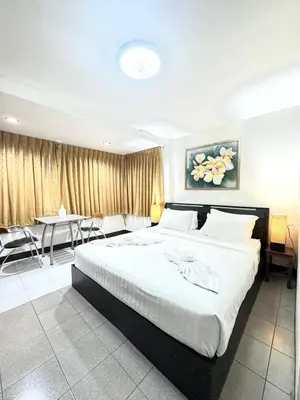 a bedroom with a large bed and a dining room at La Casa Residencies in Patong Beach