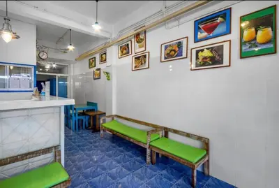 a waiting room with green benches against a white wall at La Casa Residencies in Patong Beach