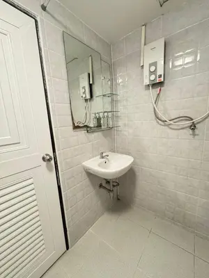 a white bathroom with a sink and a mirror at La Casa Residencies in Patong Beach