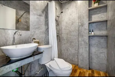 a bathroom with a white toilet and a sink at La Casa Residencies in Patong Beach