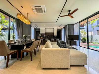 a dining room and living room with a couch and chairs at The Ozone Luxury Villas Phuket in Laguna Phuket