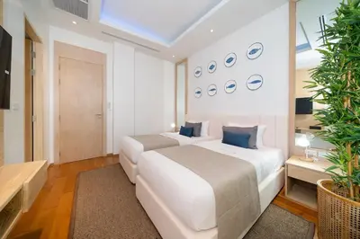 two beds in a white room with blue pillows at The Exclusive Sky D4 \u8c6a\u534e4\u5367\u5ba4\u6d77\u666f\u522b\u5885 \u79c1\u4eba12m\u65e0\u8fb9\u6d77\u666f\u6cf3\u6c60 \u6bcf\u65e5\u6e05\u6d01 in Kamala Beach