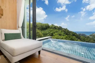 a room with a chair and a swimming pool at The Exclusive Sky D4 \u8c6a\u534e4\u5367\u5ba4\u6d77\u666f\u522b\u5885 \u79c1\u4eba12m\u65e0\u8fb9\u6d77\u666f\u6cf3\u6c60 \u6bcf\u65e5\u6e05\u6d01 in Kamala Beach