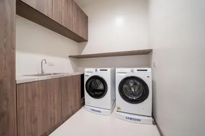 a laundry room with a washer and dryer next to a sink at The Exclusive Sky D2 \u8c6a\u534e4\u5367\u5ba4\u6d77\u666f\u522b\u5885 \u79c1\u4eba12m\u65e0\u8fb9\u6d77\u666f\u6cf3\u6c60 \u6bcf\u65e5\u6e05\u6d01 in Kamala Beach