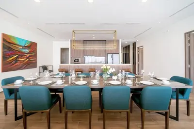a dining room with a large table and blue chairs at The Exclusive Sky D2 \u8c6a\u534e4\u5367\u5ba4\u6d77\u666f\u522b\u5885 \u79c1\u4eba12m\u65e0\u8fb9\u6d77\u666f\u6cf3\u6c60 \u6bcf\u65e5\u6e05\u6d01 in Kamala Beach